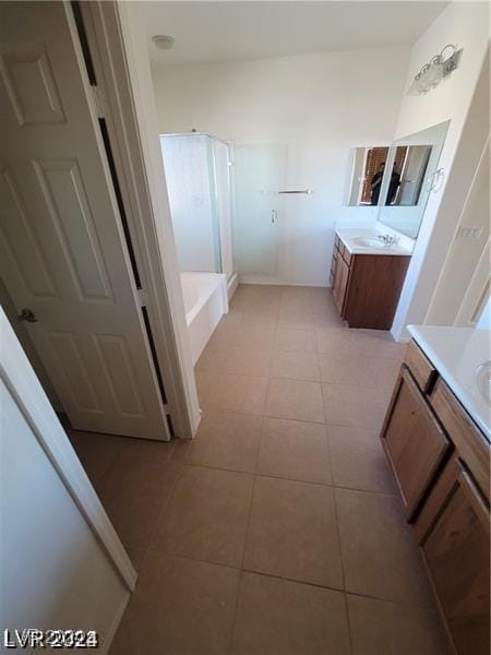 full bath featuring tile patterned floors, two vanities, a bath, and a shower stall