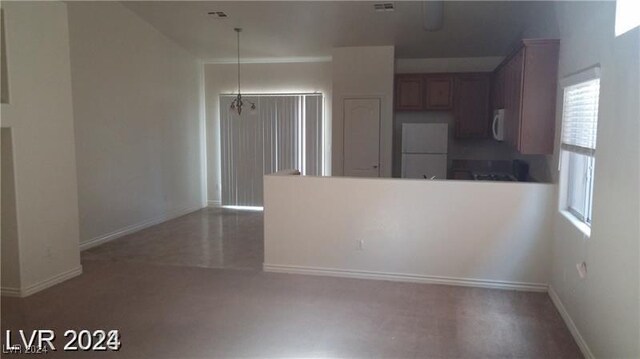 kitchen with white appliances and concrete floors