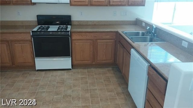 kitchen featuring light tile patterned flooring, dishwasher, electric stove, light stone countertops, and sink