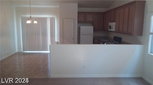 kitchen featuring decorative light fixtures, tile patterned floors, white appliances, and an inviting chandelier