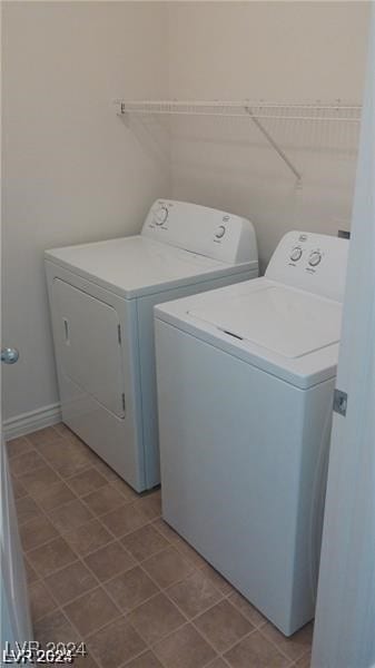 clothes washing area with washing machine and dryer and light tile patterned floors