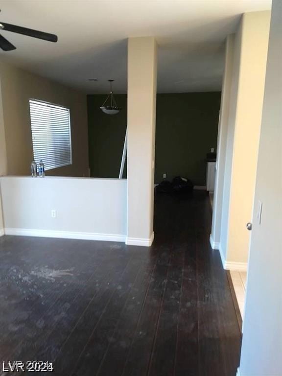 empty room featuring baseboards, ceiling fan, and wood-type flooring