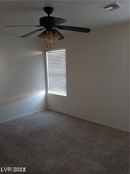 spare room with visible vents, carpet flooring, baseboards, and ceiling fan