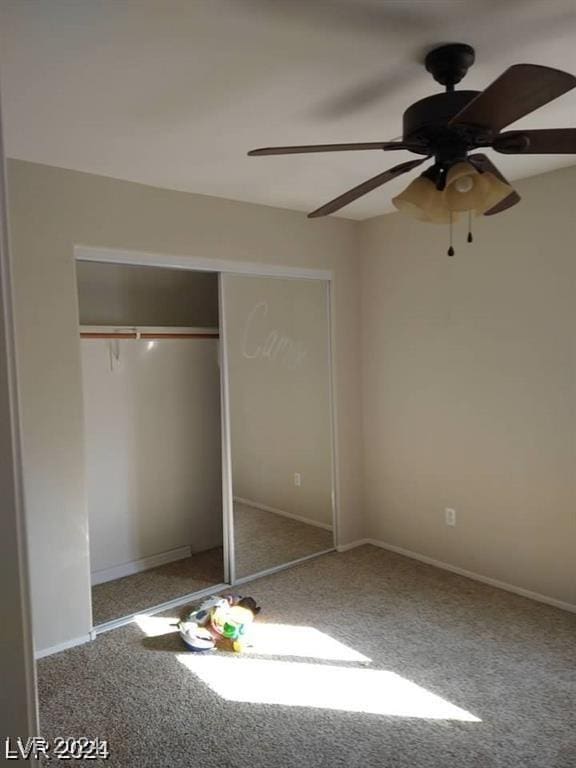 unfurnished bedroom with a closet, carpet floors, baseboards, and a ceiling fan