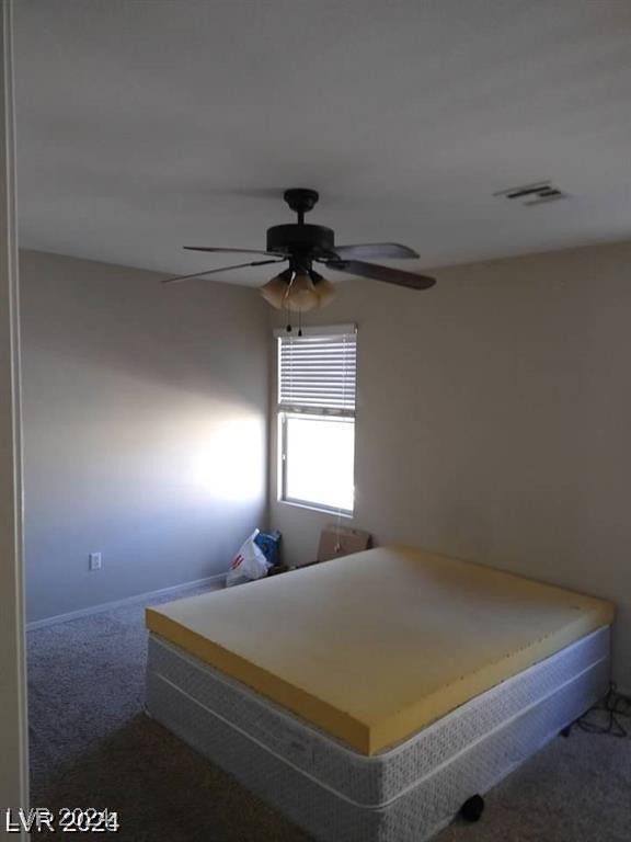 carpeted bedroom featuring a ceiling fan and visible vents