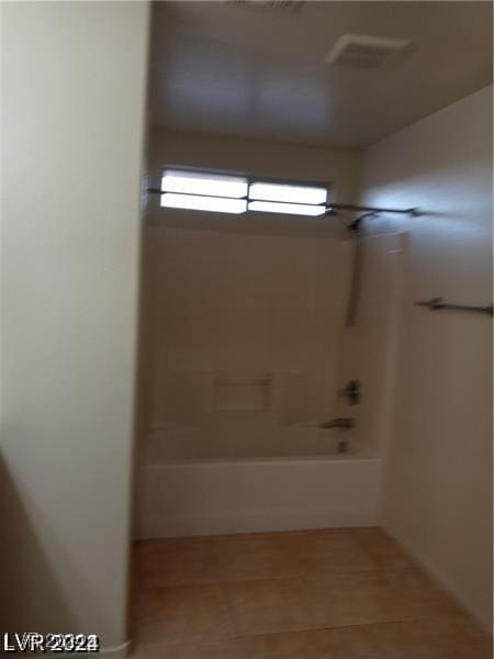 full bath featuring tile patterned flooring and washtub / shower combination