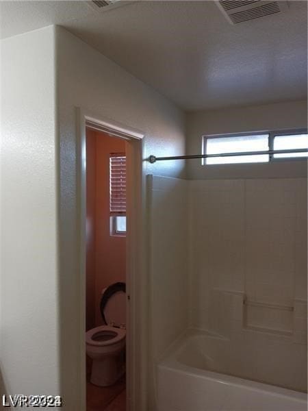 bathroom with shower / bathing tub combination and toilet