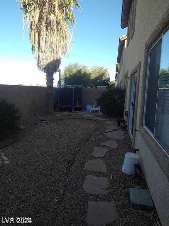 view of yard featuring a trampoline and a patio area