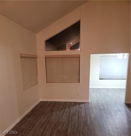 spare room featuring lofted ceiling and dark wood-type flooring