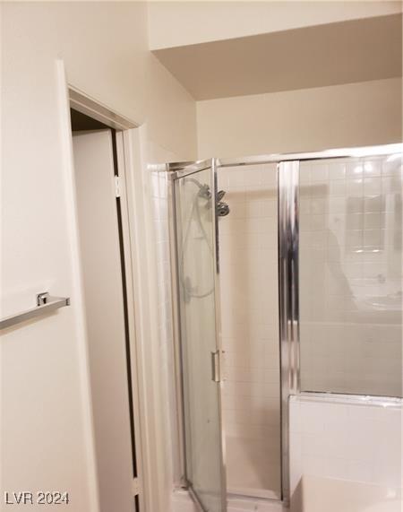 bathroom with a shower with door