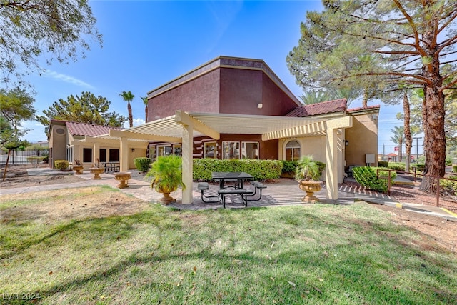 rear view of property featuring a yard, a pergola, and a patio area