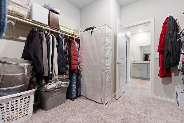 walk in closet featuring light carpet