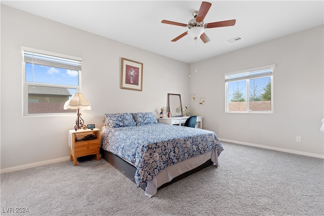 carpeted bedroom featuring multiple windows and ceiling fan