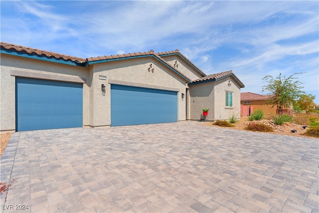 mediterranean / spanish home featuring a garage