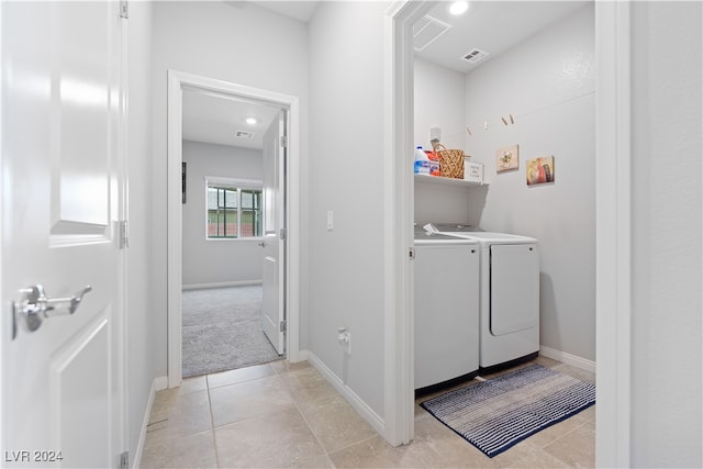 laundry area with separate washer and dryer and light tile patterned floors