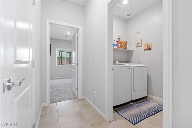 laundry room with washer and dryer and light tile patterned floors