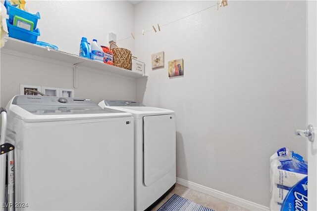 laundry area featuring separate washer and dryer and light tile patterned flooring