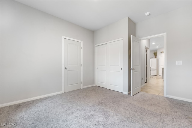 unfurnished bedroom featuring light carpet, a closet, and white fridge