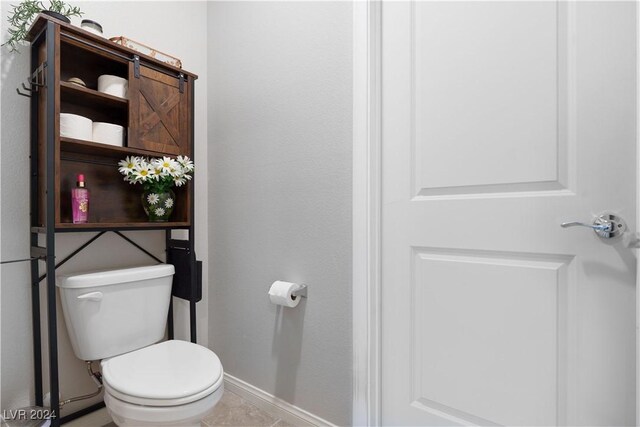 bathroom with toilet and tile patterned flooring