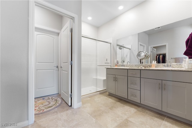 bathroom with tile patterned floors, double sink vanity, and an enclosed shower