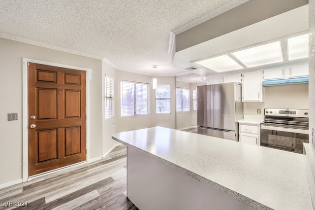 kitchen featuring white cabinets, light wood-type flooring, ornamental molding, appliances with stainless steel finishes, and a textured ceiling