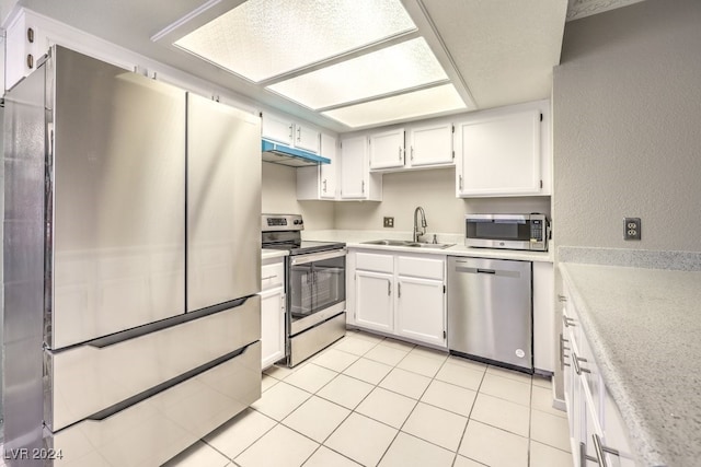 kitchen featuring sink, appliances with stainless steel finishes, white cabinets, and light tile patterned floors