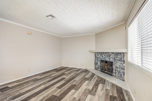 unfurnished living room with a fireplace, a textured ceiling, crown molding, and hardwood / wood-style flooring