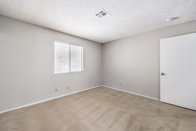 unfurnished room featuring carpet flooring and a textured ceiling