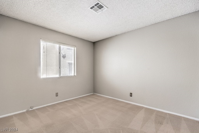 carpeted empty room featuring a textured ceiling