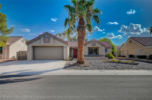 view of front of home with driveway, an attached garage, a tiled roof, and stucco siding