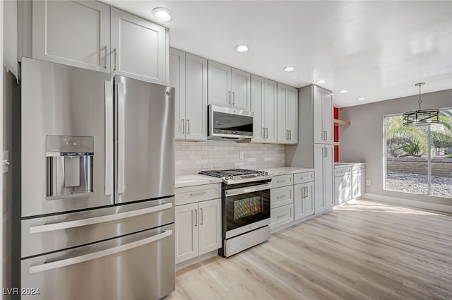 kitchen with light wood finished floors, decorative backsplash, light stone counters, stainless steel appliances, and open shelves