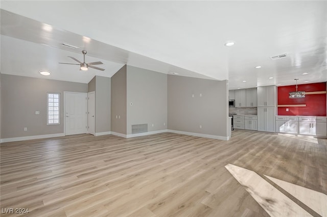 unfurnished living room featuring light wood finished floors, baseboards, visible vents, and a ceiling fan