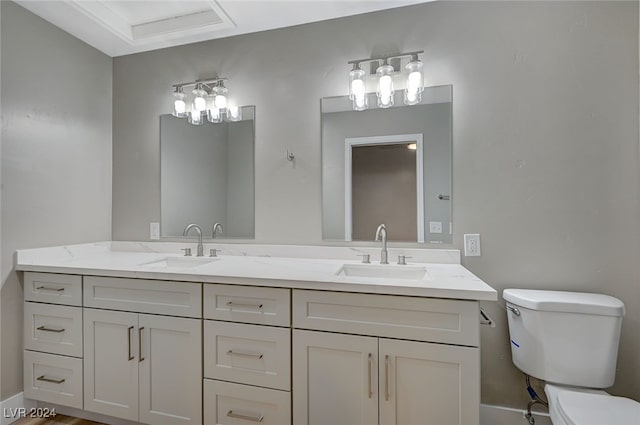 full bathroom with a sink, toilet, and double vanity