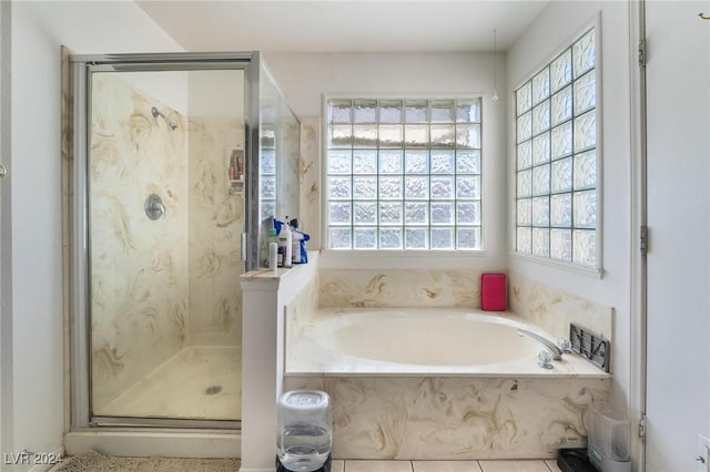 bathroom with a garden tub, a shower stall, and a wealth of natural light