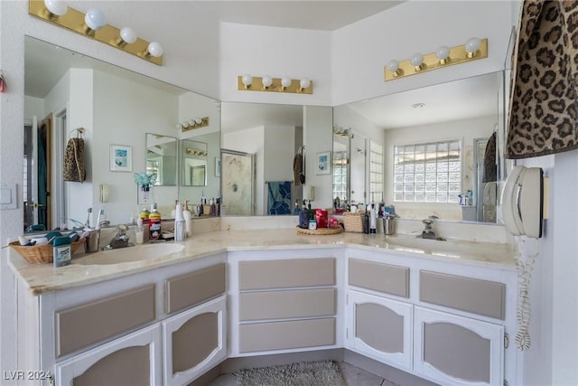 bathroom featuring a stall shower, a sink, and double vanity