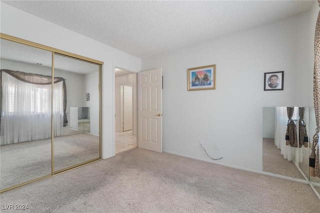 unfurnished bedroom with a closet, a textured ceiling, and carpet flooring