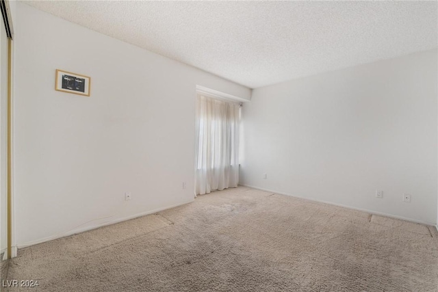 empty room with a textured ceiling and carpet floors