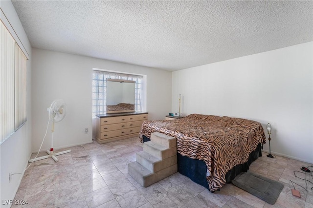 bedroom with a textured ceiling and baseboards