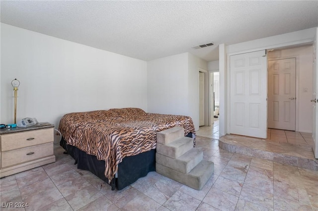 bedroom with visible vents and a textured ceiling