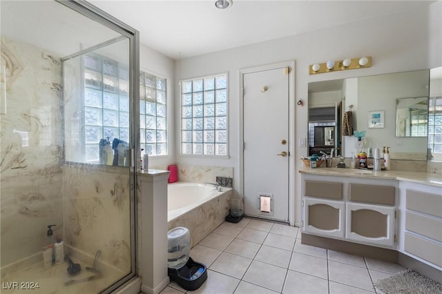 bathroom featuring a stall shower, vanity, a garden tub, and tile patterned floors