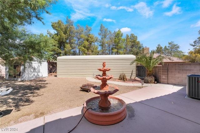 view of patio with an outdoor structure, central AC, fence, and a storage shed