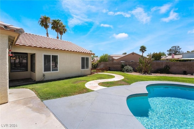 view of swimming pool featuring a fenced in pool, a patio area, a fenced backyard, and a lawn