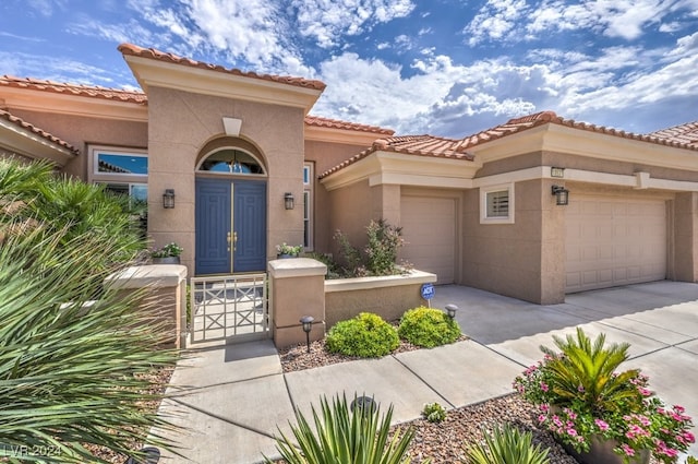 mediterranean / spanish-style house featuring a garage, concrete driveway, and stucco siding