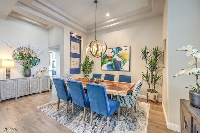 dining area featuring a chandelier, recessed lighting, baseboards, light wood-style floors, and a tray ceiling