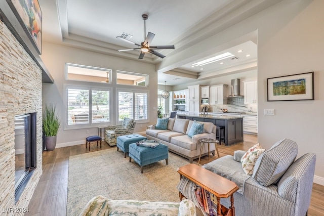 living room with visible vents, a tray ceiling, and light wood-style flooring