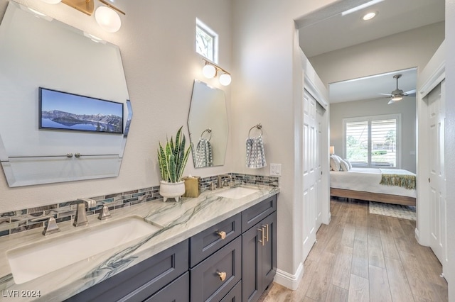 full bathroom featuring wood finished floors, a sink, decorative backsplash, and ensuite bathroom