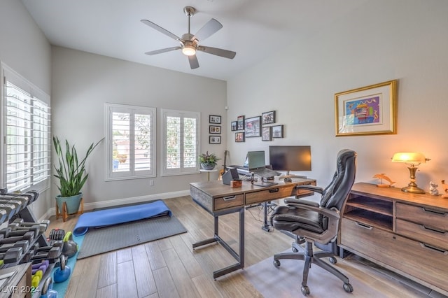 office space with light wood-type flooring, baseboards, and a ceiling fan