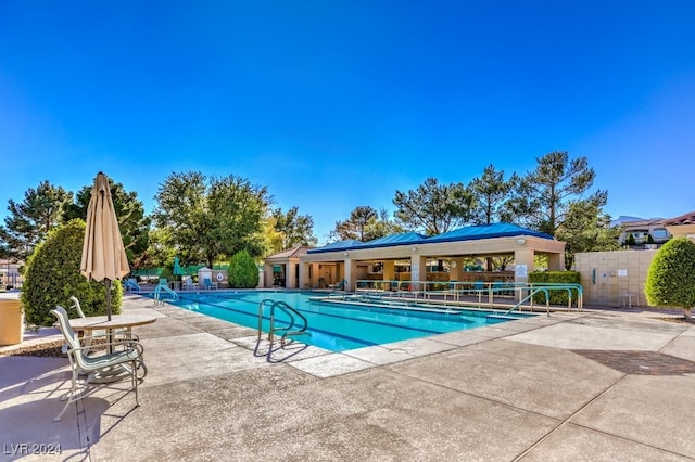 community pool with a patio and fence