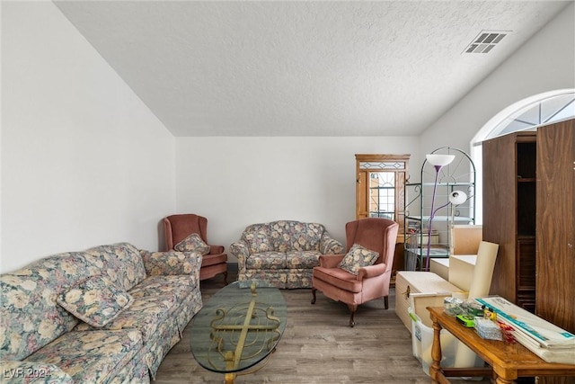 living room featuring light wood-type flooring and a textured ceiling