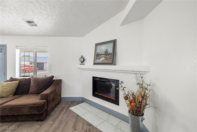 living room featuring light wood-type flooring and a textured ceiling